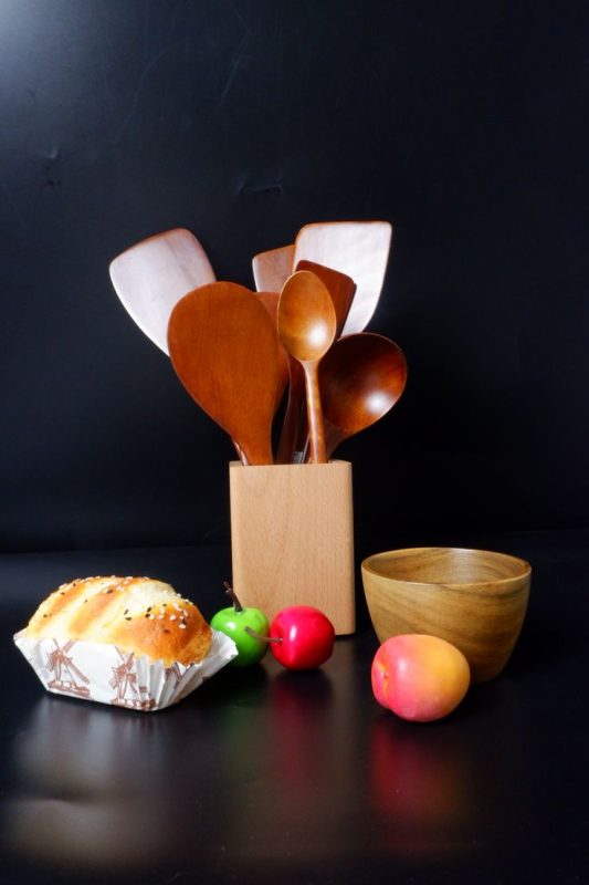 Wooden cooking spoon and fruits on the table
