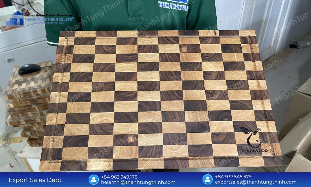 A unique mosaic checkerboard wooden block displayed on a production table for teak wood cutting board wholesale trade
