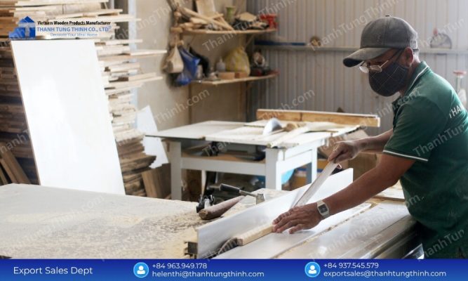 A factory worker carefully smoothing out edges to meet global export standards for a teak wood cutting board supplier.