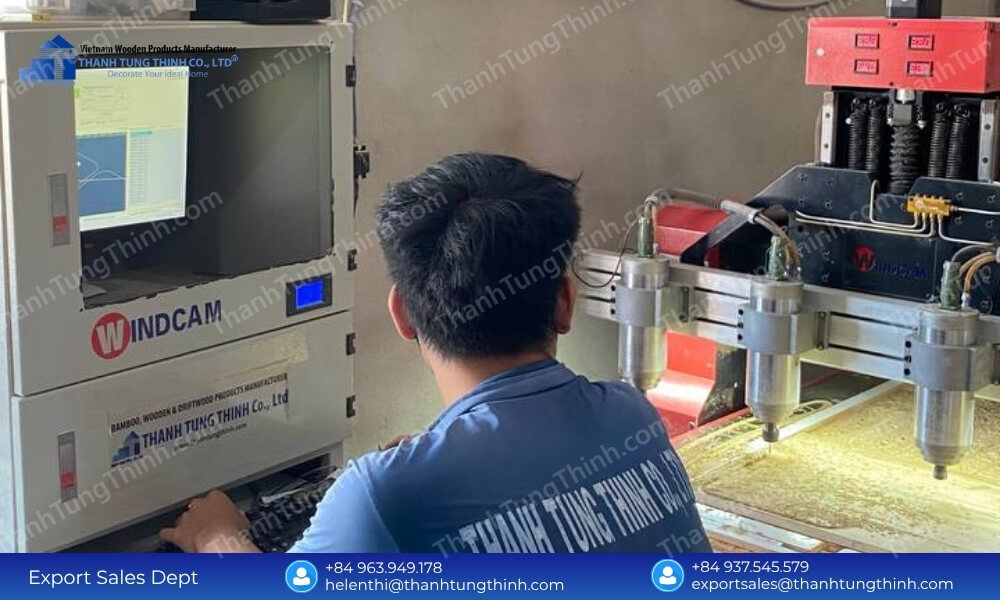 Rear view of a technician looking at a specialized Windcam monitor to configure numerical toolpaths for an industrial CNC router unit