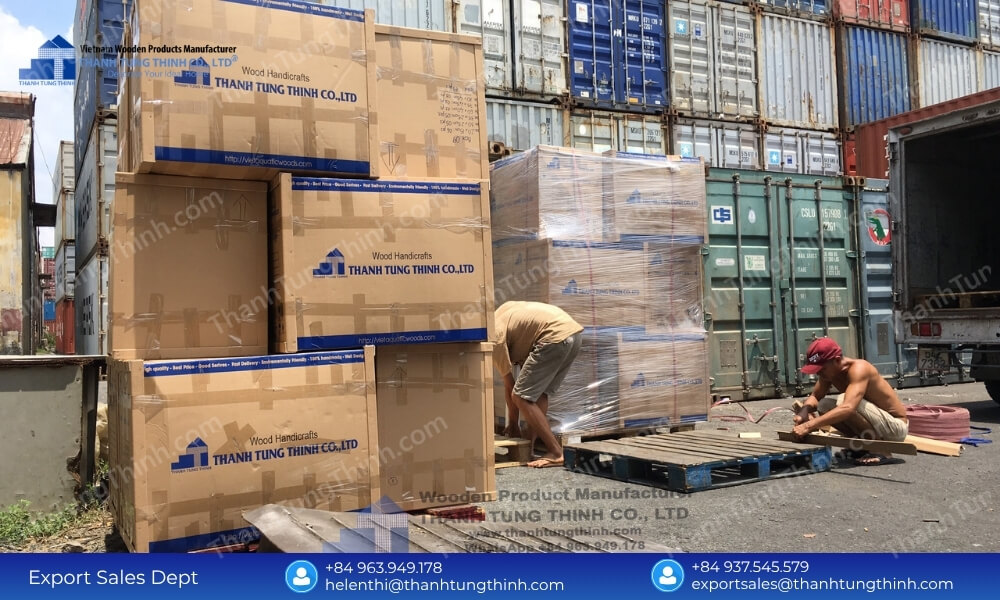 Large cardboard boxes packed on shipping pallets and wrapped in protective stretch film outside with ocean containers behind