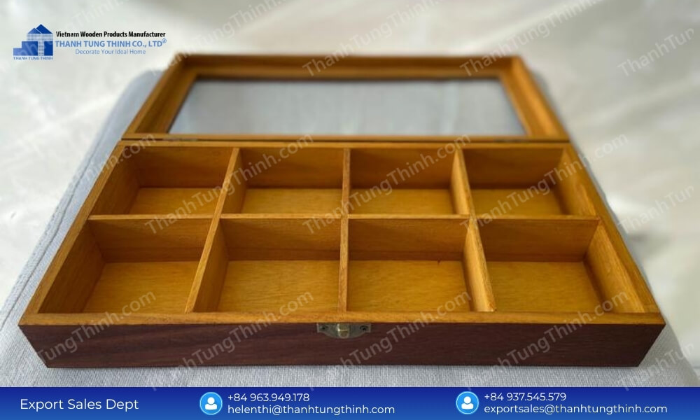 An open eight-compartment rectangular wooden storage tray featuring a rich natural wood grain pattern and a front metal clasp