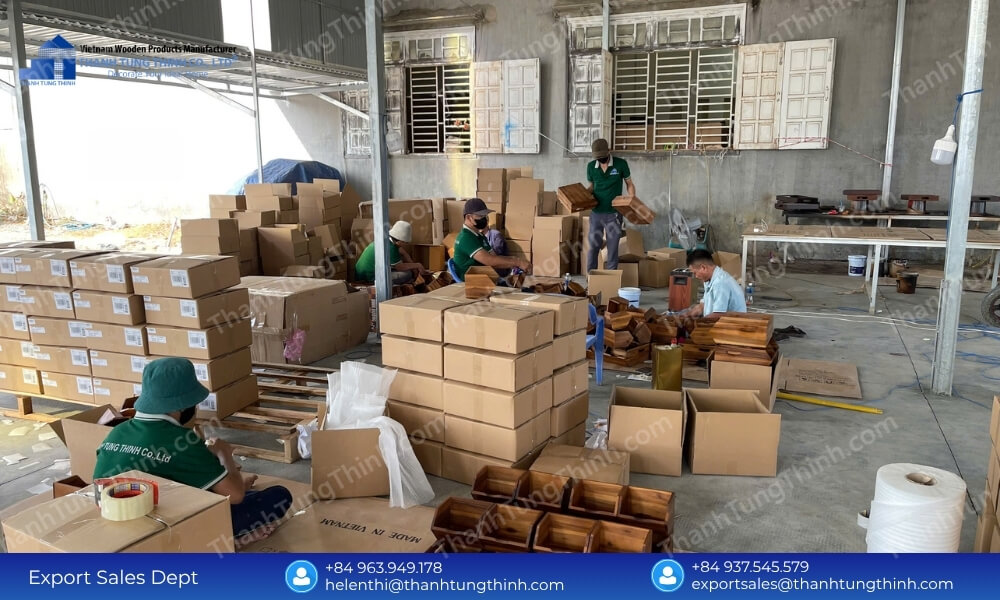 An indoor workshop scene with stacked storage cartons and wooden components neatly organized across the assembly area