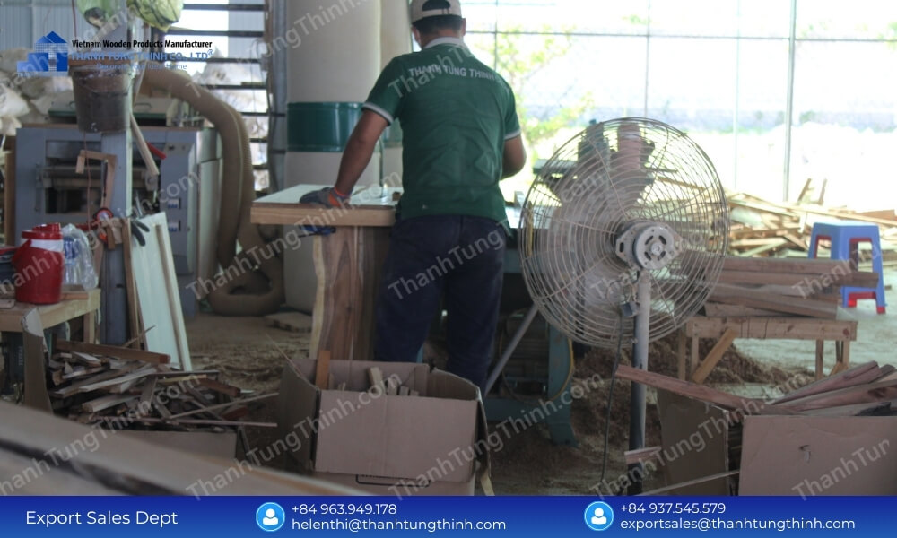 Factory technician operating a mechanized timber cutting system for wooden plates contract manufacturing