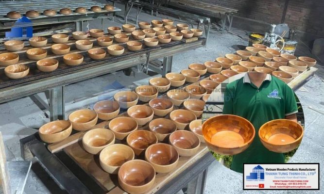 factory worker holding finished samples of a food safe wholesale wooden bowl
