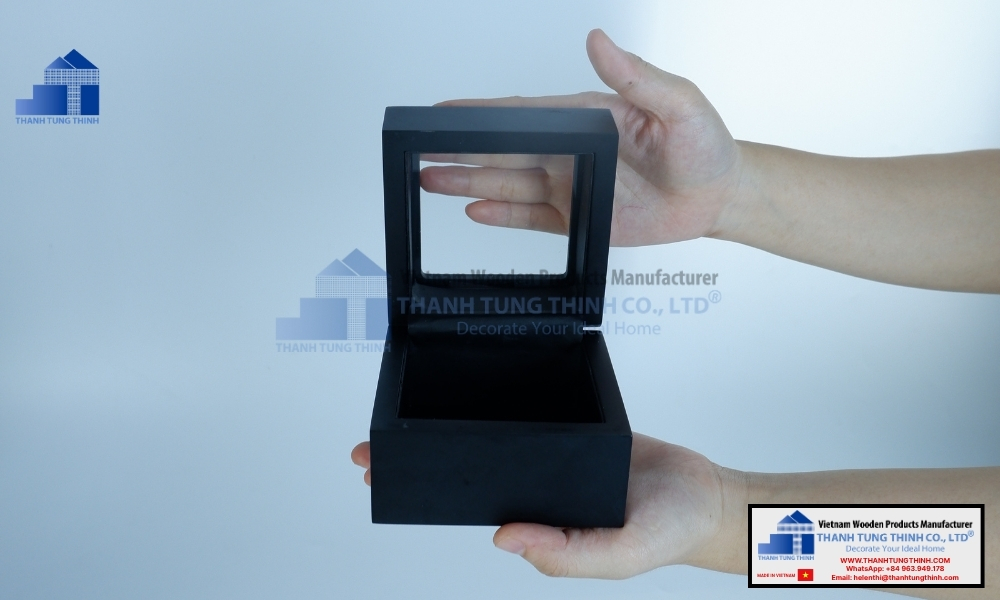 Hand holding a portable square black wooden jewelry box